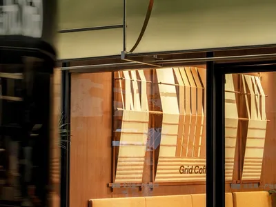 Cafe interior with wooden seating, striped curtains, and modern decor.