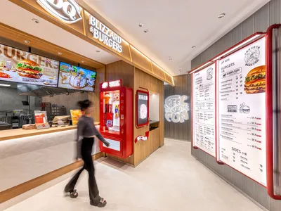 A modern interior design of a cafe featuring wooden finishes and LED lighting, with a menu board displaying burgers and sides
