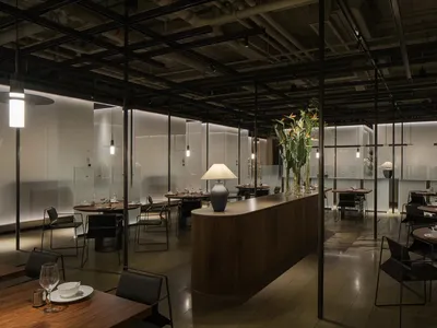現代工業風餐廳室內，搭配木質餐桌、玻璃牆面與金屬元素