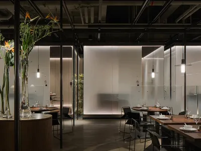 Interior design image of a modern restaurant featuring glass and concrete elements.