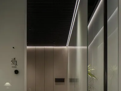 Modern restaurant interior with a minimalist design featuring metal lighting and sleek furniture.