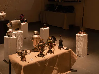A coffee shop display featuring various metal vessels and containers, showcasing a collection of coffee-making equipment and