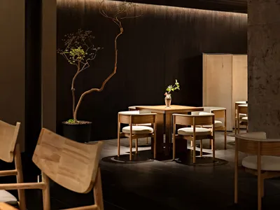 Minimalist restaurant interior with wooden furniture and dark walls
