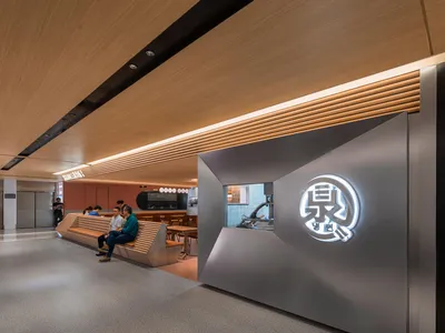 A sleek, modern restaurant interior with metallic and wooden elements and a illuminated sign.