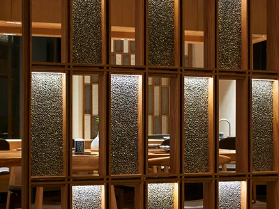 A modern restaurant interior showcasing wooden walls and windows.