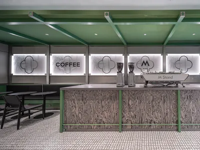 Interior view of a modern coffee shop featuring a counter made of light-colored wood.
