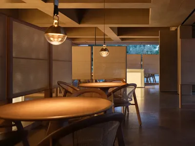 現代簡約餐廳，配有木質餐桌椅、溫暖燈光與自然元素。