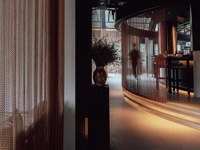 A modern-looking restaurant interior with glass curtains and a cozy ambiance.
