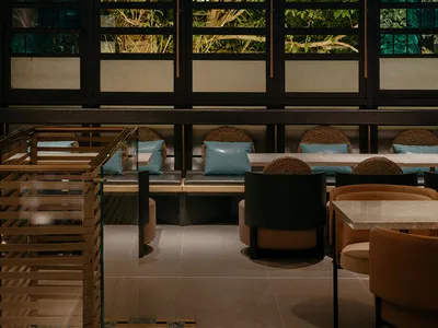A modern restaurant interior featuring wood and leather materials.