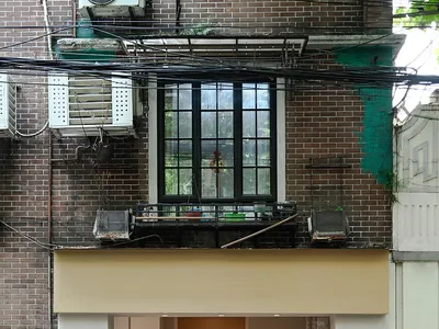 A photograph of a storefront with a concrete facade viewed from the street.