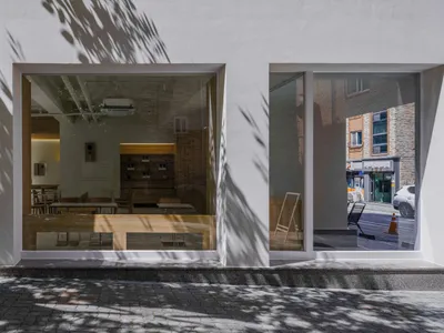 A modern restaurant interior with glass walls and white walls