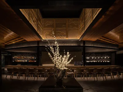 A modern restaurant interior featuring wooden decor and lighting.