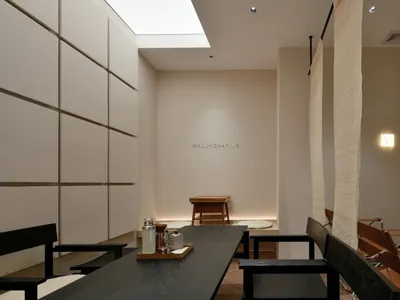 簡約風格的餐廳室內，配有木質餐桌椅、柔和燈光及天窗。