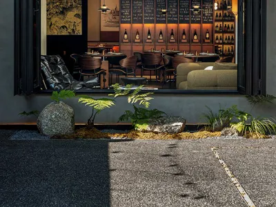 Modern restaurant bar with wooden furniture and concrete walls, featured in a Brewbar & Kitchen setting.