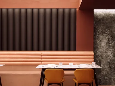 A modern restaurant interior with concrete and leather materials.