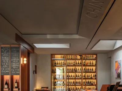 Modern restaurant interior with wooden bar counter and concrete flooring