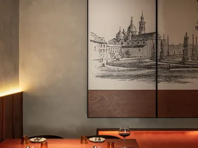 Modern restaurant interior with wooden tables, metal chairs, and glassware.