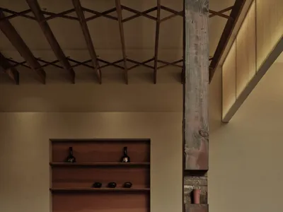 Modern restaurant interior with wooden beams, fabric textiles, and clay decor