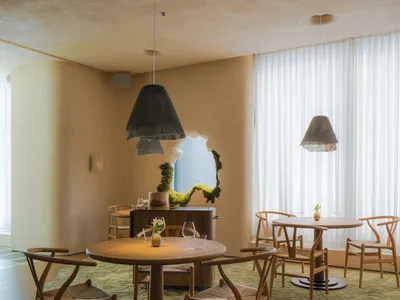 舒適的餐廳用餐區，搭配木質餐桌、綠色地毯與吊燈。