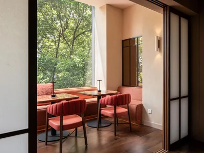 A cozy restaurant interior featuring a modern design with fabric seating and wooden accents.