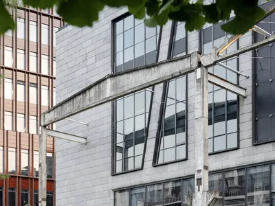 Modern restaurant exterior with concrete facade and large glass windows.