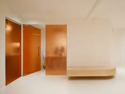 An interior design photograph showcasing modern hospitality features, including glass walls and minimalist furniture.