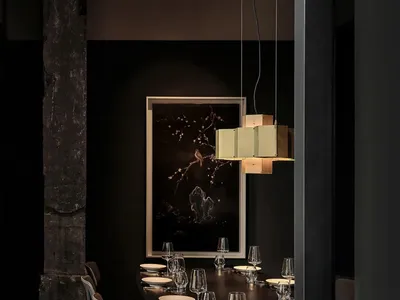Modern minimalist restaurant interior with black walls, dark wooden tables, and metallic accents.