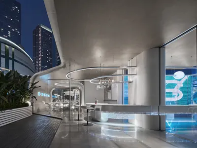 時尚現代的酒店酒吧，採用混凝土與玻璃材質，設有圓形吧台、盆栽植物及當代元素