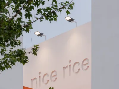 現代極簡餐廳外觀，採用混凝土牆面搭配明亮橘色瓷磚點綴。