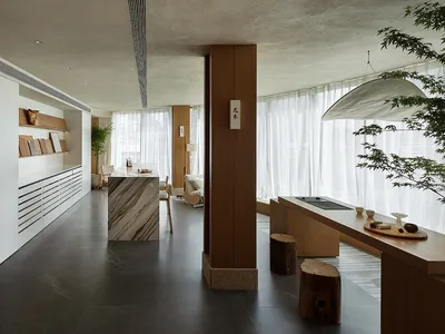 A modern showroom featuring a kitchen display with marble countertops and wooden accents.