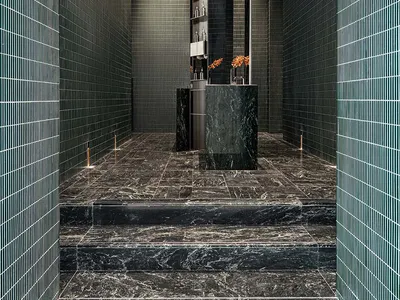 Modern hotel lobby with marble floors and walls, featuring a sleek reception desk area.