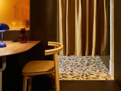 A modern home office space featuring terrazzo tiles on the floor, a sleek table, and a comfortable chair.