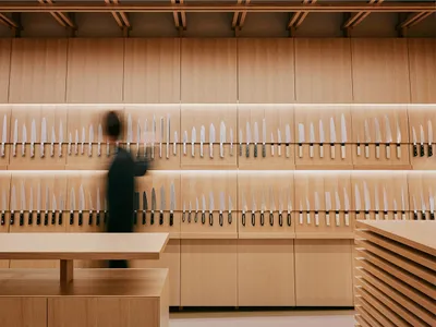 一間現代廚房刀具店，牆面陳列各式刀具、木質層架與柔和燈光。