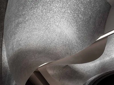 A modern, curved metallic staircase with a sleek, futuristic design