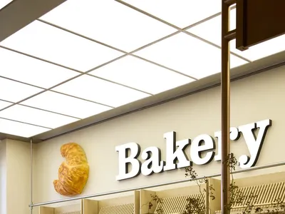 Modern bakery with wooden shelves and a sign reading 'Bakery'.