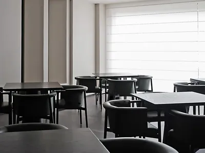 A modern restaurant interior featuring glass tables and minimalist design.
