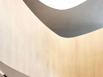 簡約餐廳內部，木質座椅、混凝土牆面搭配金屬點綴。