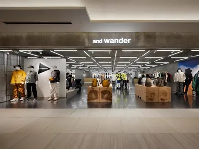現代零售店面採用混凝土地板，陳列 And Wander 服飾與配件。