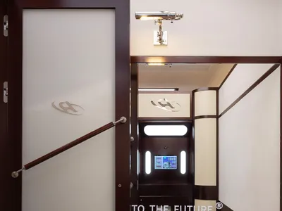 A futuristic lounge interior with brown walls and a white frosted glass door.