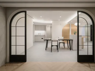 A minimalist modern home office with a concrete floor and white walls.