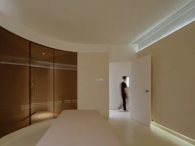 Minimalist bedroom featuring glass and concrete elements