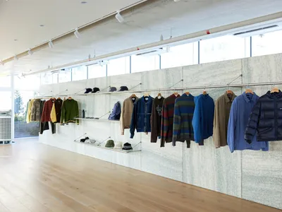 店內服裝展示，架上與衣架陳列多款外套與配件。
