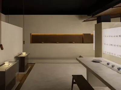 Clean, minimalist restaurant interior with concrete walls and countertops, illuminated by soft, ambient lighting.