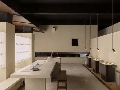 Minimalist restaurant interior with concrete countertops and wooden stools