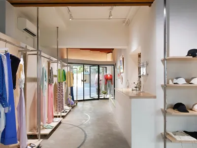 服裝零售店內有混凝土牆面、玻璃展示櫃，以及木質裝飾元素。