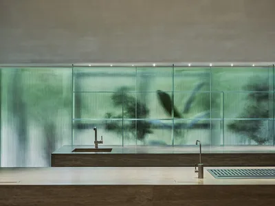 Modern kitchen featuring a marble countertop and a glass dividing wall.