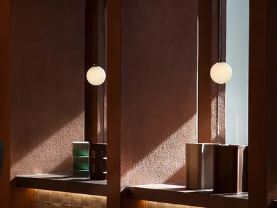 A cozy cafe interior featuring warm lighting, cement-tile surfaces, and modern fixtures.