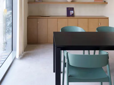 A modern restaurant dining room featuring wooden furniture, ambient lighting, and decorative items.