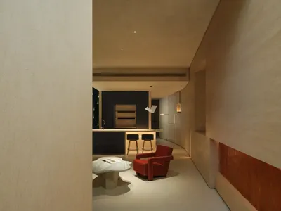 現代廚房採用黑白金屬飾面，設有吧台與高腳椅，以及紅色扶手椅。