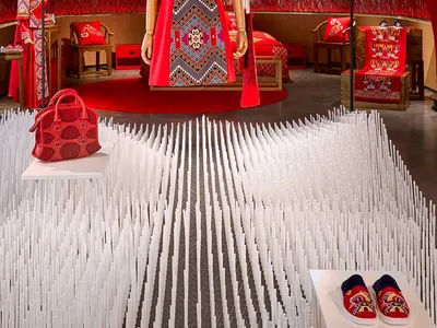 Fashion retail display featuring a red textile design with intricate patterns and traditional elements.